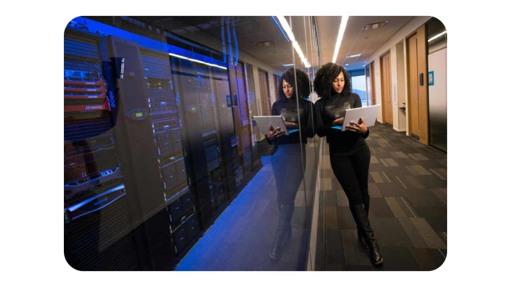 engineer holding laptop at server farm